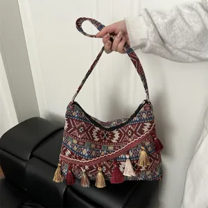 Vista detallada del bolso de hombro tejido de estilo étnico vintage con elegantes borlas.