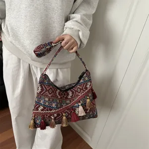 Bolso cruzado de lona estilo étnico retro para mujer con detalles de borlas y patrón geométrico.