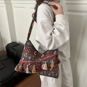 Bolso de hombro de lona estilo étnico retro con patrones geométricos y borlas elegantes.