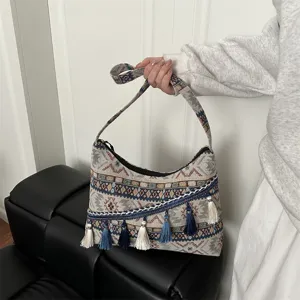 Bolso de hombro etnico retro tejido con detalles de borlas y textura de lona elegante.