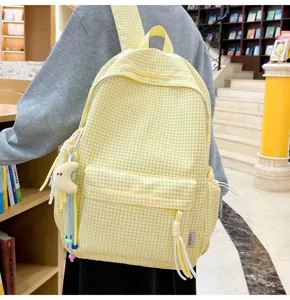 Gelber Karomuster Rucksack Detailansicht, lässige Schultasche mit Vordertasche und Mondanhänger.