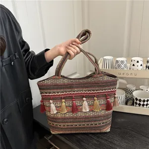 Ethnic style woven canvas tote bag featuring colorful stripes and chic tassels for women.