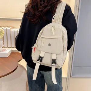 Gedetailleerd overzicht van een casual beige nylon rugzak met meerdere zakken en gespen.