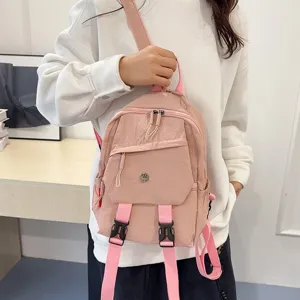 Roze casual kleine rugzak detailweergave met praktische voorzakken voor dagelijks gebruik.