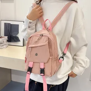 Gedetailleerd overzicht van roze nylon rugzak met voorvak met rits en verstelbare banden.