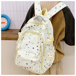 Detailed view of a white canvas backpack with cute star prints, multiple zipped pockets, and straps.