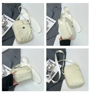 Close-up detail of a beige mini crossbody phone bag with zipper pocket and strap.