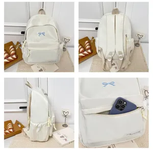Japanese sweet style white student backpack detail featuring cute blue bow embroidery and pocket.