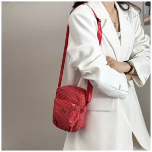 Compact red checkered crossbody bag with front zipper pocket and adjustable strap for daily use.