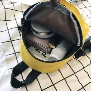 Canvas mini crossbody bag interior detail showing storage capacity and daily essentials inside.