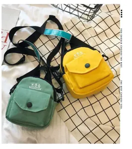 Cute canvas crossbody bag for women, stylish small shoulder bag with front pocket design.