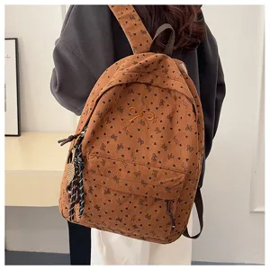 Brown corduroy backpack for women featuring cute bow prints, embroidery, and stylish charms.