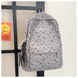 Detailed view of grey corduroy backpack with cute bow prints and embroidered letters.