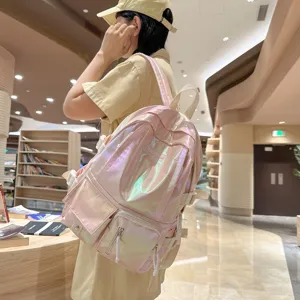 Détail du sac à dos rose holographique brillant mettant en valeur ses poches avant.
