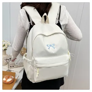 Sweet Japanese style white backpack for school girls with cute blue bow embroidery detail.