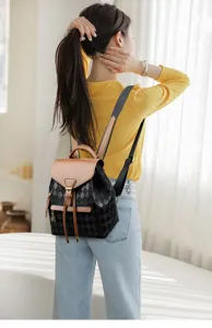 Vue arrière détaillée d'un sac à dos élégant pour femme noir matelassé avec un rabat marron chic.