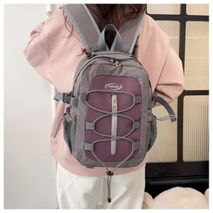 Detail view of the contrast color backpack with bungee cord, showing back wear effect clearly.
