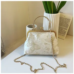 Elegant white gold butterfly kiss-lock clutch handbag with chain strap for women detail view.