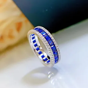 Plano detalle de un anillo de plata S925 con piedras azules y circonitas brillantes.