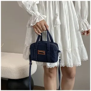 Nahaufnahme der Retro-Jeanshandtasche mit Reißverschluss und dunkelblauem Stoffmuster.