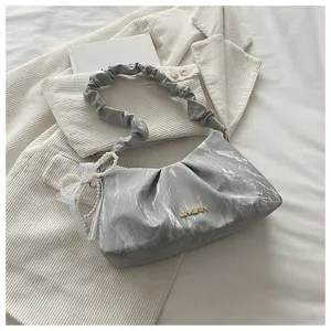 Detail view of grey pleated cloud shoulder bag, minimalist niche design with pearl strap.