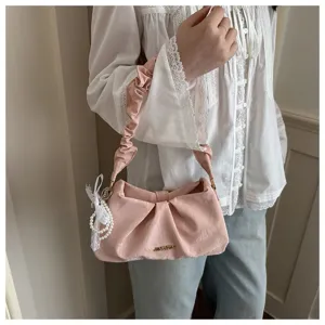 Details of the pink ruched shoulder bag featuring cute pearl and lace pendant and soft pleats.