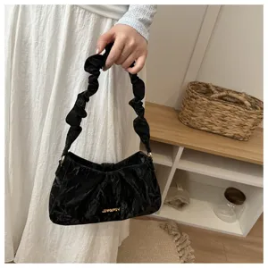 Black ruched shoulder bag detail view, minimalist cloud handbag with gathered strap.