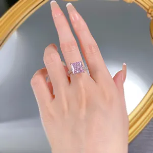 Impresionante anillo de diamante corte princesa rosa con banda pavé, vista detallada.