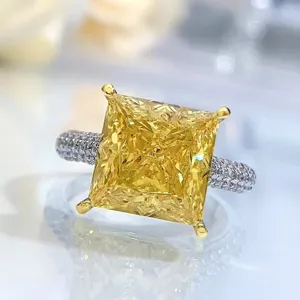 Primer plano detalle del anillo de diamante amarillo talla princesa con brillante pavé.