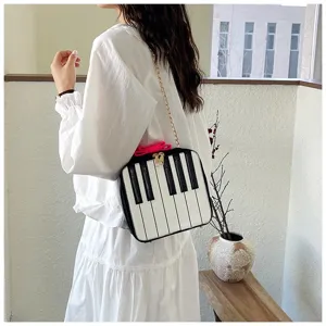 Detail shot of cute piano key chain crossbody bag with bow and strap for women everyday fashion.