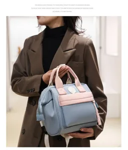 Stylish lightweight mommy bag in light blue and pink, versatile backpack for modern mothers.