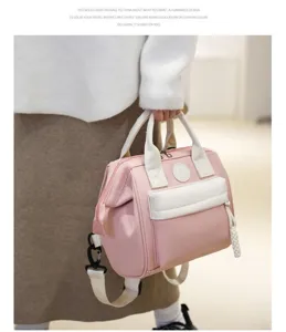Stylish pink mommy diaper bag, versatile waterproof backpack and tote handbag for daily use.