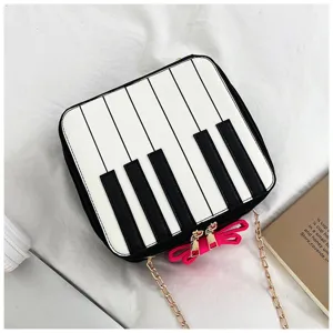 Piano keys design crossbody bag with cute pink bow and gold chain strap, stylish mini shoulder bag.