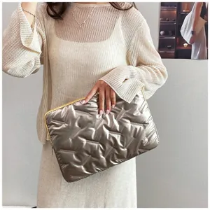 Detailed view of the glossy metallic embossed PU leather clutch bag showcasing its soft texture.