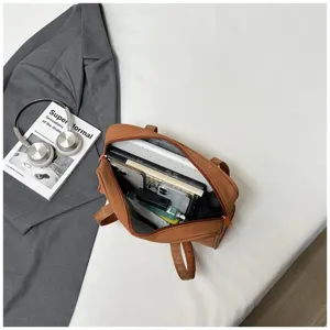 Detail view of brown large capacity shoulder laptop bag showcasing inner storage and items.