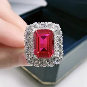 Detailansicht des luxuriösen rubinroten Rings mit Smaragdschliff und doppeltem Diamantkranz.