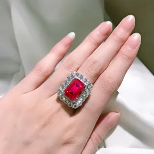 Nahaufnahme eines luxuriösen roten Edelsteinrings mit funkelndem Diamant-Halo-Detail.