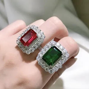 Exquisites Smaragd Schliff Edelstein Ring Detail mit luxuriösem Rubin und grünem Halo Design.