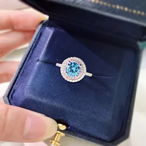 Close-up detail of a stunning double halo silver ring with a vibrant blue center stone.