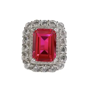 Luxuriöser Damenring mit rotem Edelstein im Smaragdschliff und strahlendem Diamantkranz.