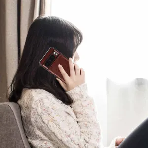 Vista detallada de la funda de teléfono de cuero marrón con ranura para tarjeta y soporte.