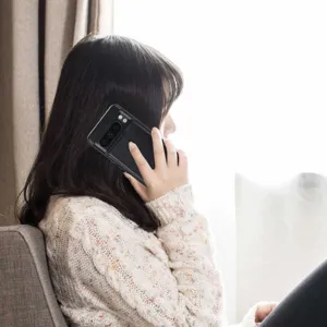 Vista detallada de una funda de teléfono de cuero negro con tarjetero en uso real.