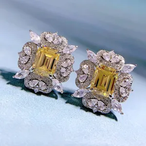 Nahaufnahme Detail luxuriöser Ohrringe mit gelbem Smaragdschliff und funkelndem Pavé-Halo.