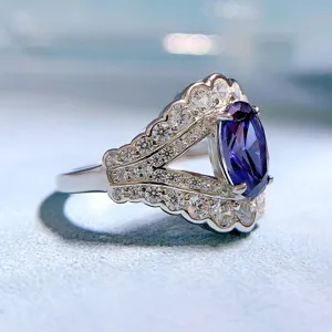 Primo piano dettagliato di anello in argento con gemma viola ovale e zirconi scintillanti.