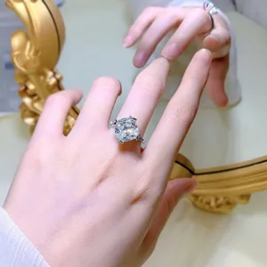 Close-up van een schitterende kussengeslepen diamantring om de hand met heldere details.