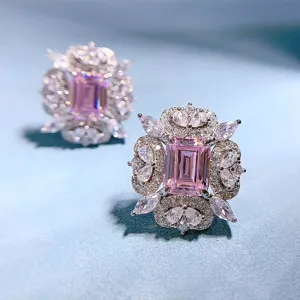 Detailaufnahme luxuriöser rosa Ohrringe im Smaragdschliff mit funkelnden Zirkonia-Steinen.
