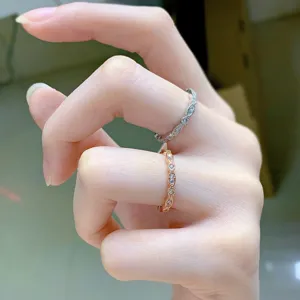 Primer plano detallado de delicados anillos apilables de plata S925 y oro rosa con piedras.