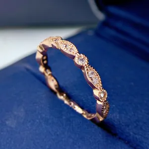 Primer plano detallado del anillo apilable de diamantes ondulados en oro rosa.