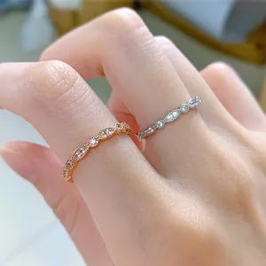 Hermoso primer plano detallado de anillos ondulados con micro-pavé en plata y oro rosa.