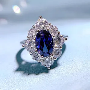 Primo piano dettagliato di un lussuoso anello in zaffiro blu ovale con alone di diamanti.